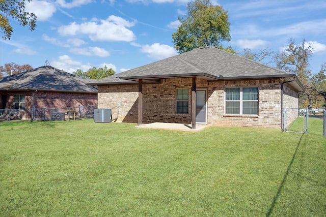 rear view of house featuring a yard and central air condition unit