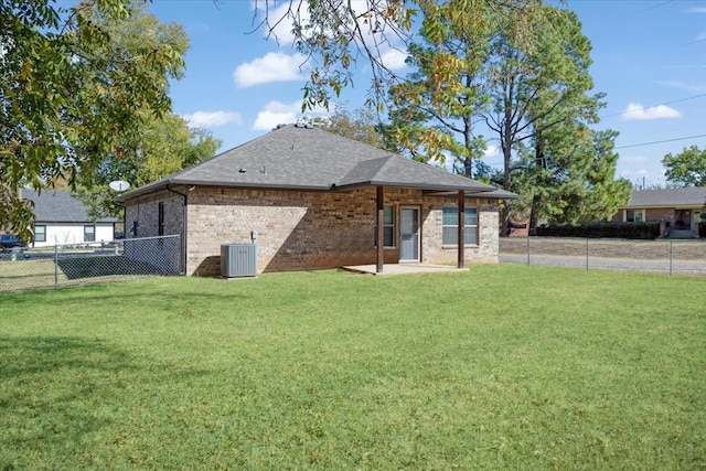 back of property with central air condition unit, a yard, and a patio