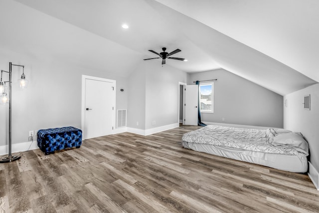 bedroom with ceiling fan, lofted ceiling, and hardwood / wood-style flooring