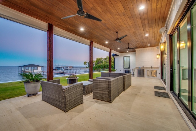 patio terrace at dusk featuring an outdoor hangout area, a water view, area for grilling, and ceiling fan