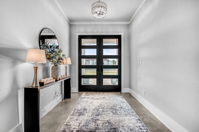 entrance foyer with french doors, concrete floors, an inviting chandelier, and ornamental molding