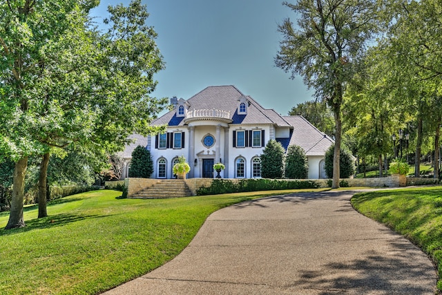 french provincial home with a front yard