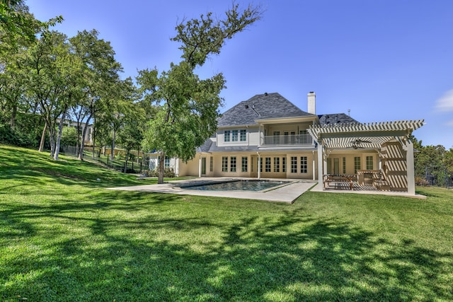 rear view of house with a patio, a lawn, and a pergola