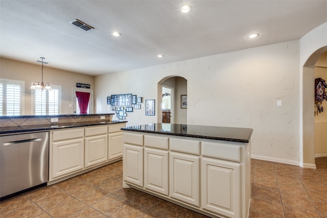 kitchen featuring light tile patterned floors, an inviting chandelier, stainless steel dishwasher, decorative light fixtures, and a center island