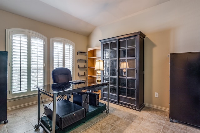 office space featuring lofted ceiling and tile patterned floors