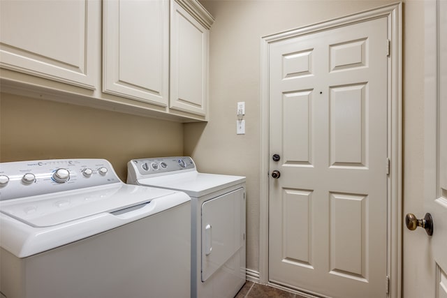 laundry room featuring dark tile patterned flooring, independent washer and dryer, and cabinets