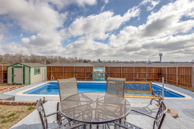 view of pool with a shed and a patio