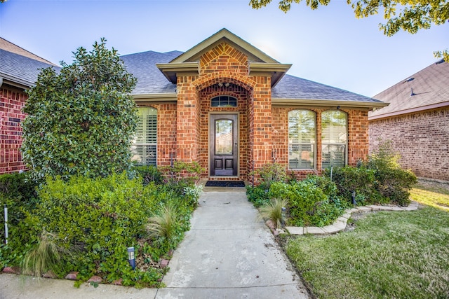 entrance to property featuring a lawn