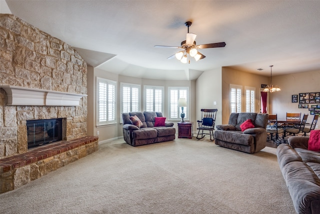 living room featuring a fireplace, carpet floors, and ceiling fan with notable chandelier