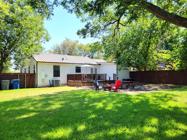 back of house featuring central AC, a wooden deck, a yard, and a patio