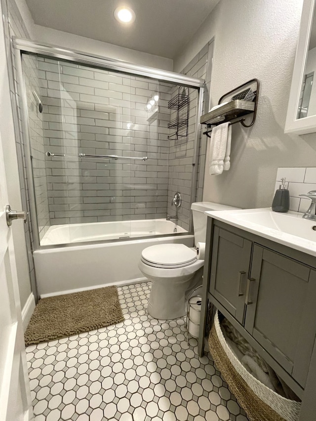 full bathroom with vanity, toilet, and bath / shower combo with glass door