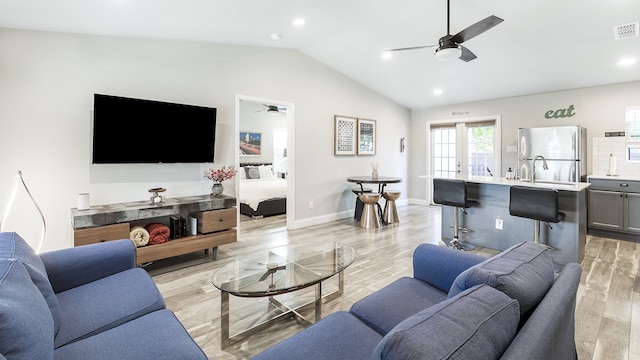 living room with lofted ceiling, french doors, light wood-type flooring, and ceiling fan