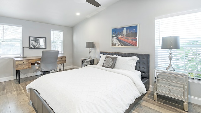 bedroom with multiple windows, hardwood / wood-style floors, ceiling fan, and vaulted ceiling