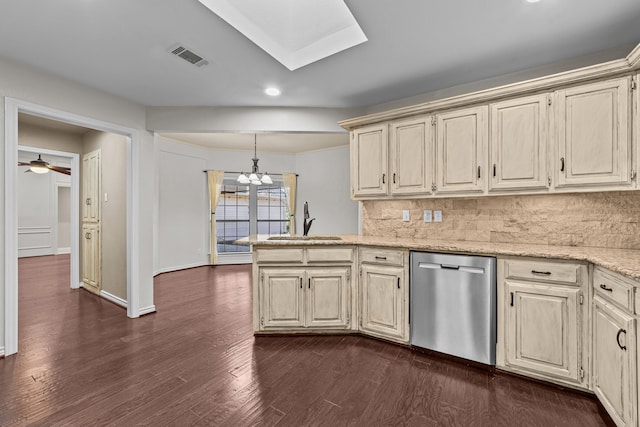 kitchen featuring dishwasher, decorative backsplash, dark wood-type flooring, hanging light fixtures, and sink