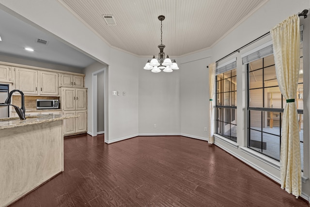 kitchen with ornamental molding, light stone countertops, pendant lighting, an inviting chandelier, and dark hardwood / wood-style flooring