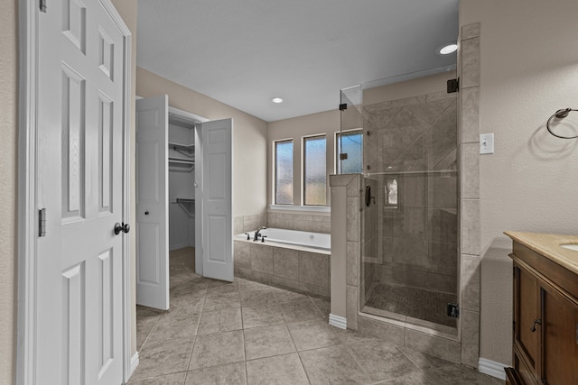 bathroom featuring vanity, shower with separate bathtub, and tile patterned flooring