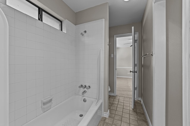 bathroom with toilet, tile patterned flooring, and tiled shower / bath