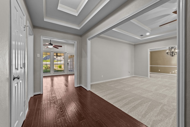 hall featuring crown molding, hardwood / wood-style flooring, a chandelier, and a raised ceiling