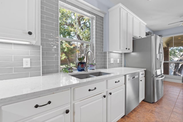 kitchen featuring white cabinetry, tasteful backsplash, appliances with stainless steel finishes, and a sink