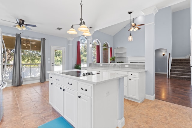 kitchen with lofted ceiling, black electric cooktop, kitchen peninsula, light tile patterned flooring, and white cabinets