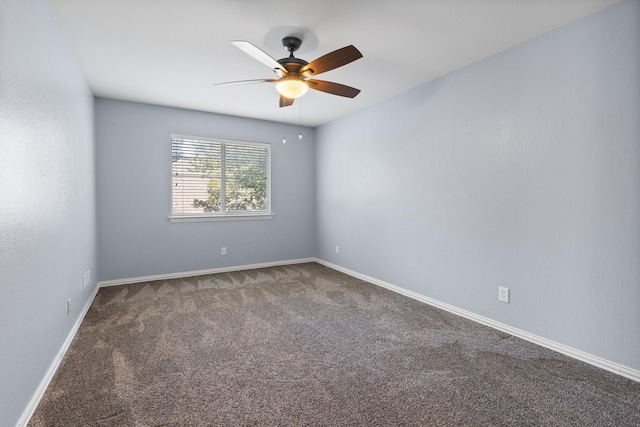 carpeted empty room featuring a ceiling fan and baseboards