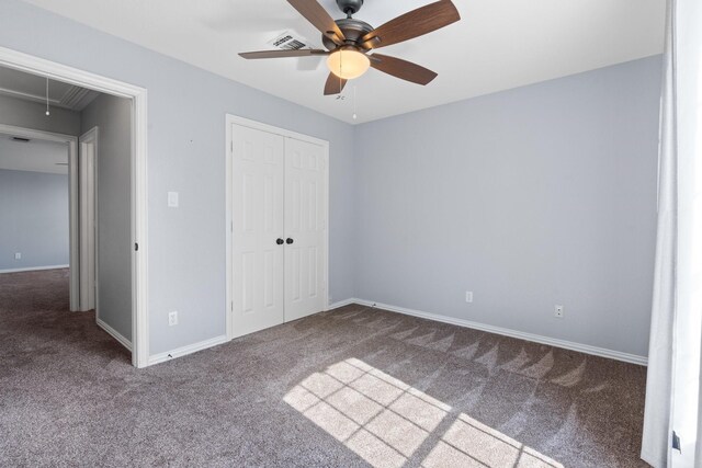 unfurnished bedroom featuring carpet, attic access, visible vents, and a closet