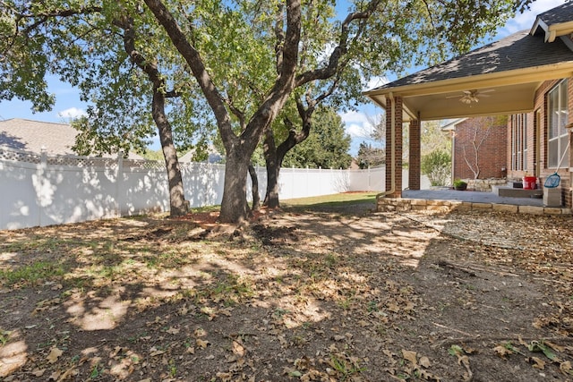 view of yard featuring a ceiling fan, a fenced backyard, and a patio area
