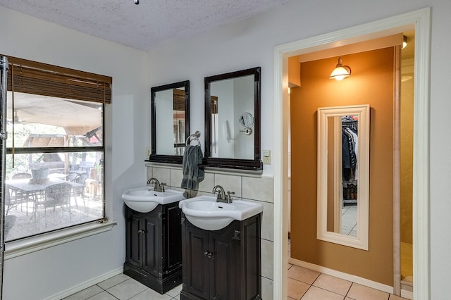 bathroom featuring vanity, a textured ceiling, and tile patterned flooring