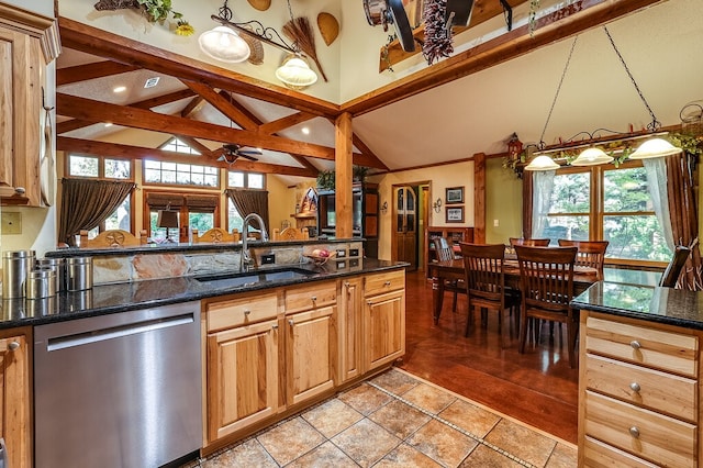 kitchen featuring ceiling fan, stainless steel dishwasher, dark stone countertops, pendant lighting, and sink