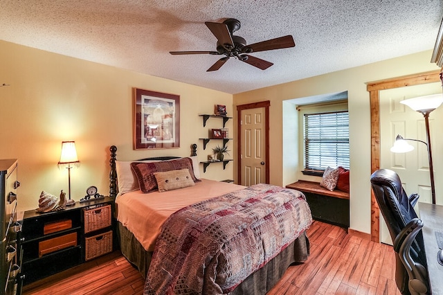 bedroom with ceiling fan, hardwood / wood-style flooring, and a textured ceiling