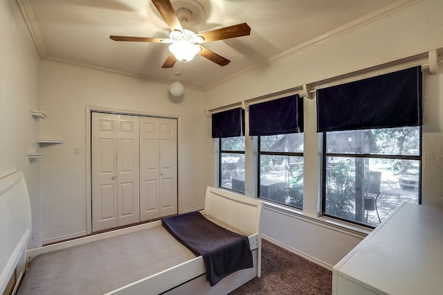 living area featuring crown molding, dark colored carpet, and ceiling fan