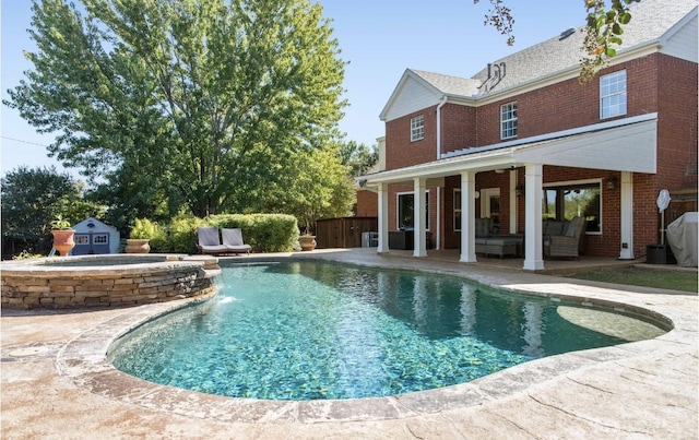 view of swimming pool featuring a storage unit, an outdoor hangout area, and a patio area