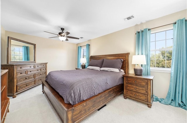 carpeted bedroom with ceiling fan and multiple windows