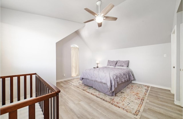 bedroom with light hardwood / wood-style flooring, vaulted ceiling, and ceiling fan