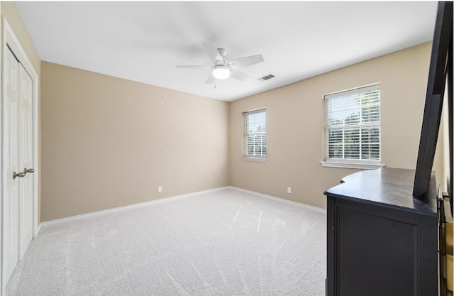 bedroom featuring light carpet, a closet, and ceiling fan