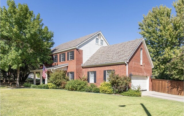 colonial home featuring brick siding, a shingled roof, a garage, and driveway