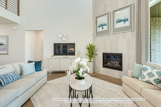 living room featuring a tiled fireplace and wood-type flooring