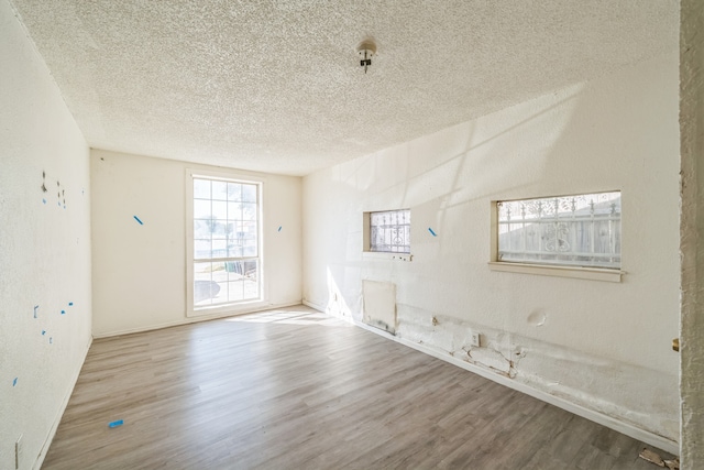 empty room featuring a textured ceiling and wood-type flooring