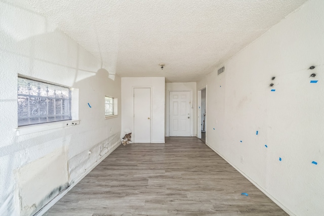 hall featuring hardwood / wood-style flooring and a textured ceiling