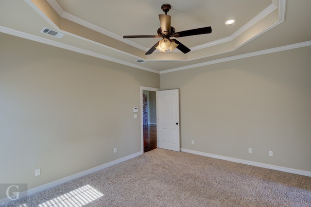 carpeted empty room with crown molding, ceiling fan, and a raised ceiling