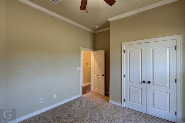 unfurnished bedroom featuring ornamental molding, light carpet, a closet, and ceiling fan