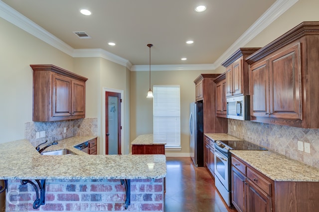 kitchen featuring sink, stainless steel appliances, a breakfast bar area, and kitchen peninsula