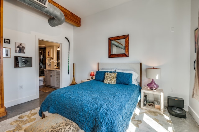 bedroom featuring concrete flooring, connected bathroom, and beam ceiling