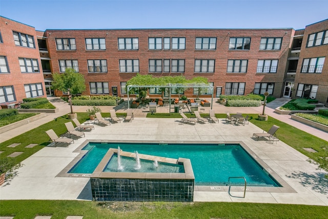 view of swimming pool featuring a jacuzzi, a patio, a pergola, and pool water feature