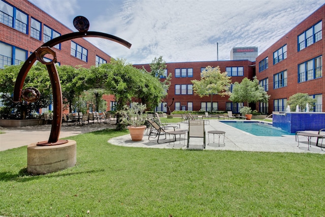 view of swimming pool featuring pool water feature, a patio area, and a yard