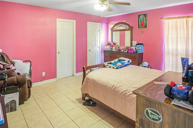 tiled bedroom with ceiling fan and baseboards