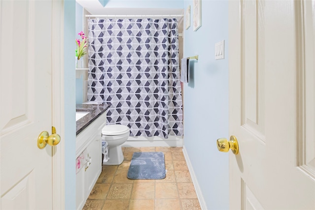 bathroom featuring vanity, curtained shower, and toilet