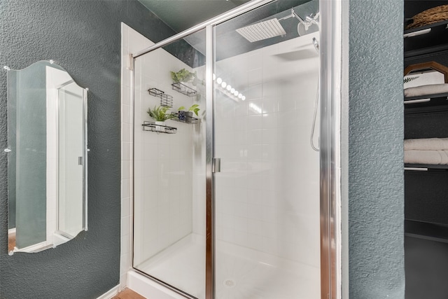 bathroom featuring a shower with door