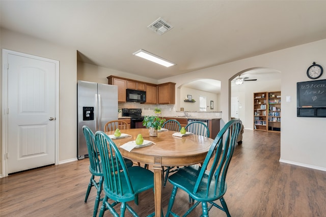 dining space with hardwood / wood-style floors and ceiling fan