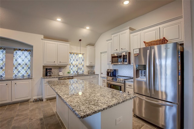 kitchen with pendant lighting, a kitchen island, white cabinets, and appliances with stainless steel finishes